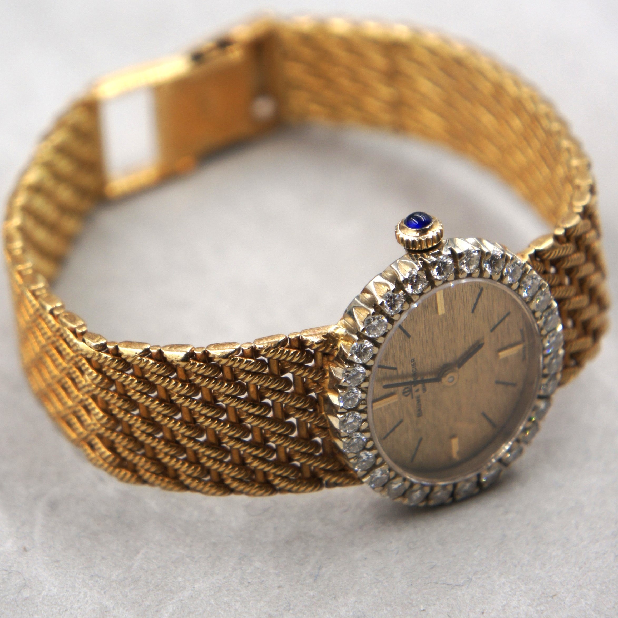 Beaume et Mercier Lady vintage watch ellipse shaped in 18 K gold and a diamonds set bezel with a manual winding movement and solid 18 K gold bracelet crown profile view