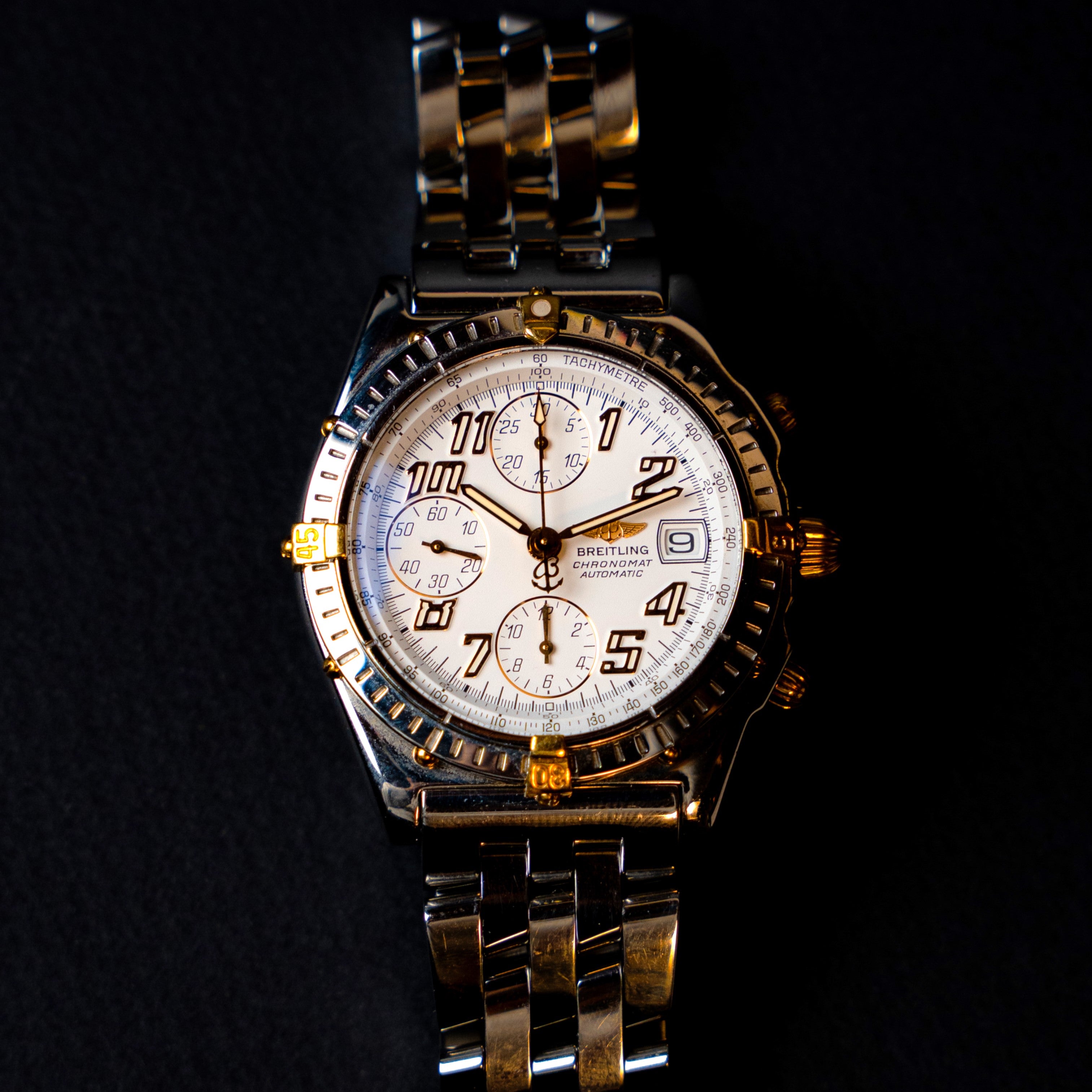 Breitling Chronomat Automatic vintage chronograph from the 90's in two-tone steel and 18 carat gold featuring a crisp white dial with gold indices, large Arabic numerals and hands with its rare original bracelet and signed double-folding clasp face view