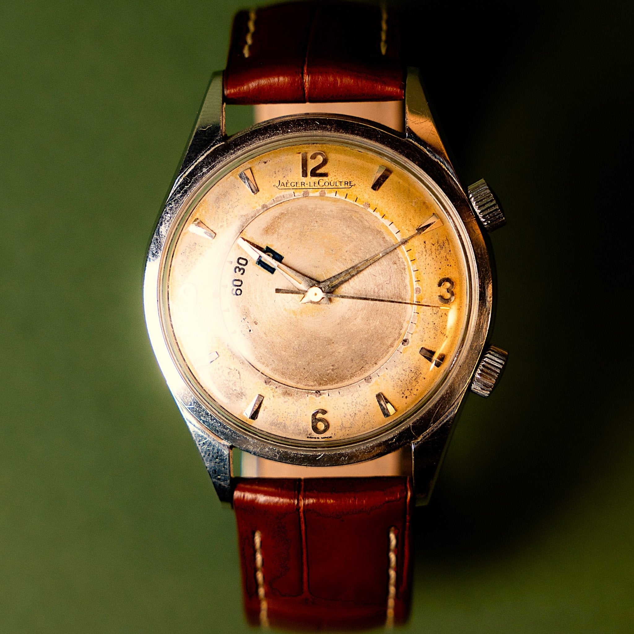 Jaeger-LeCoultre Memovox Parking acier, mouvement mécanique à remontage manuel, boîtier acier 35 mm, double couronne, cadran à belle patine miel chiffres arabes appliqués aux 12 3 6 9, indexes bâton, aiguilles dauphine dorées avec traces de tritium, disque central de stationnement, édition 125e anniversaire de la manufacture, années 1960