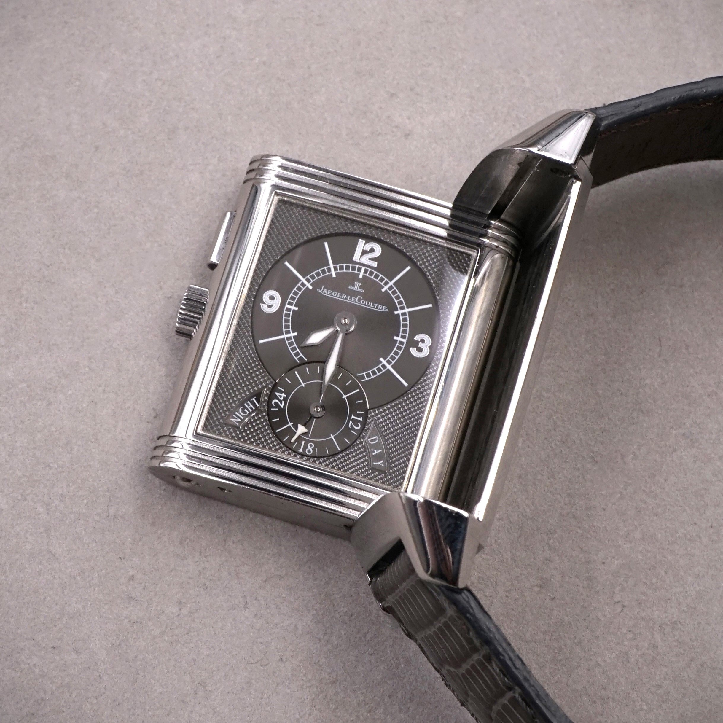 Jaeger-Lecoultre Reverso Night & Day vintage watch in steel with 2 time zones and hand wound movement on leather strap with original folding clasp night face flipped view