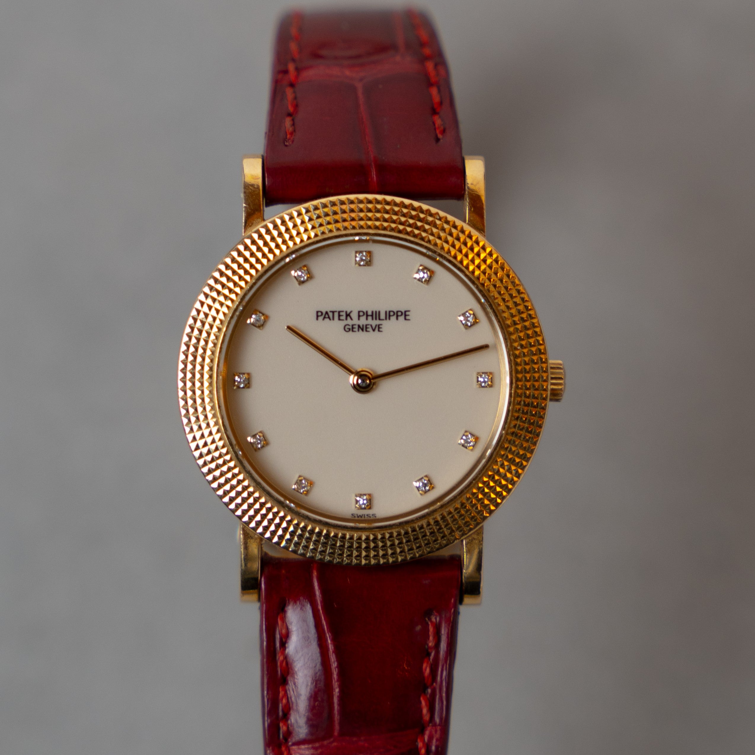 Patek Philippe Calatrava Lady vintage watch from the 80's in 18 carat yellow gold with "Clous de Paris" finish bezel and Champagne dial decorated with diamond indexes on its leather strap and its original gold pin buckle face view
