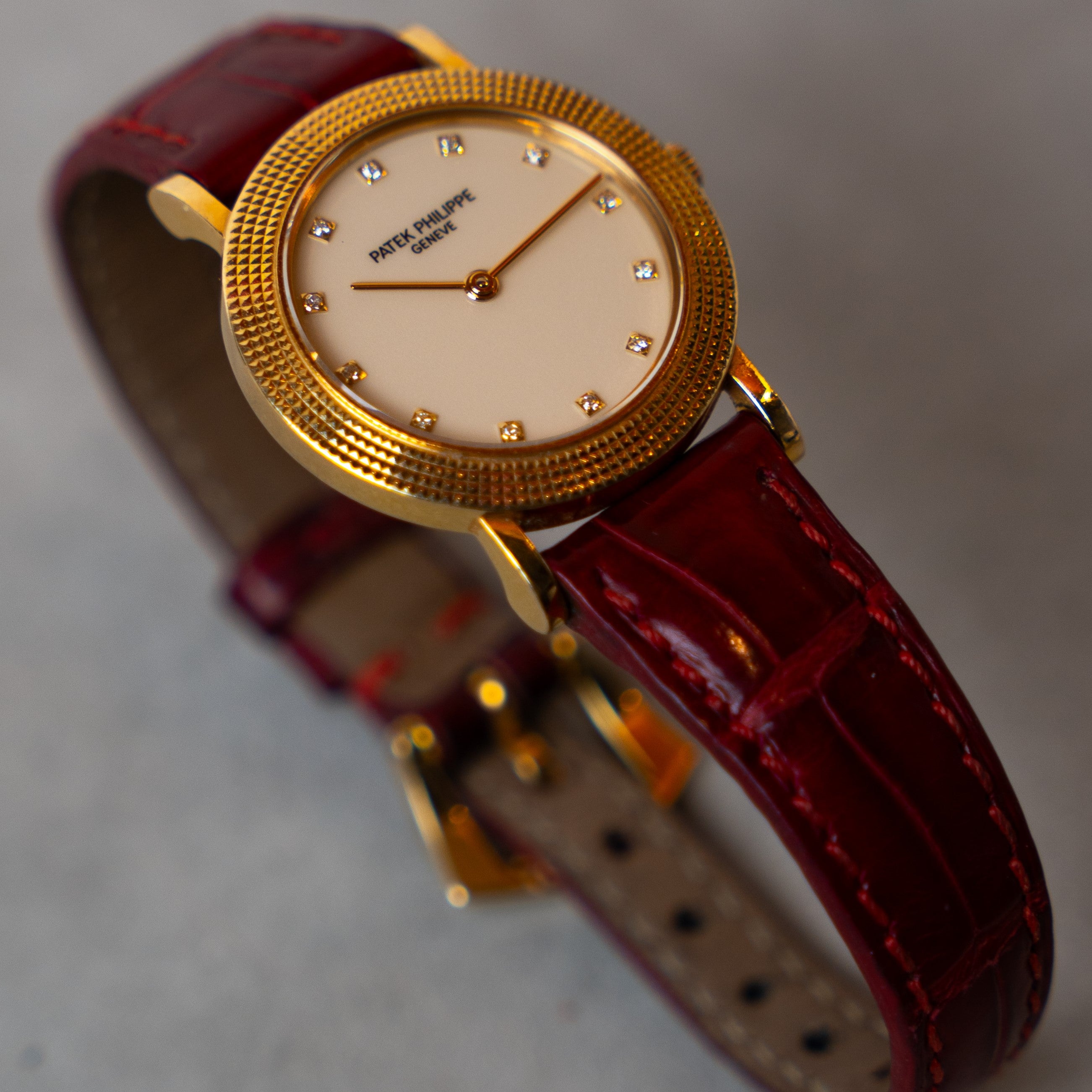 Patek Philippe Calatrava Lady vintage watch from the 80's in 18 carat yellow gold with "Clous de Paris" finish bezel and Champagne dial decorated with diamond indexes on its leather strap and its original gold pin buckle 3/4  face view