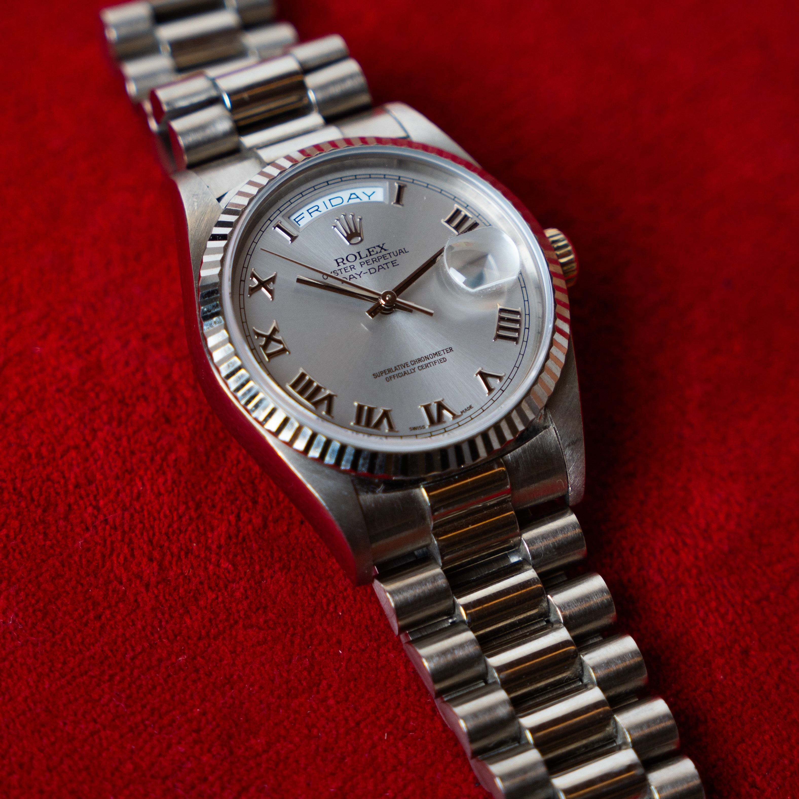 Rolex Day Date in 18 K white gold 36 MM case fluted bezel and Super President strap with a silver dial ornated with Roman numerals 3/4 angle view
