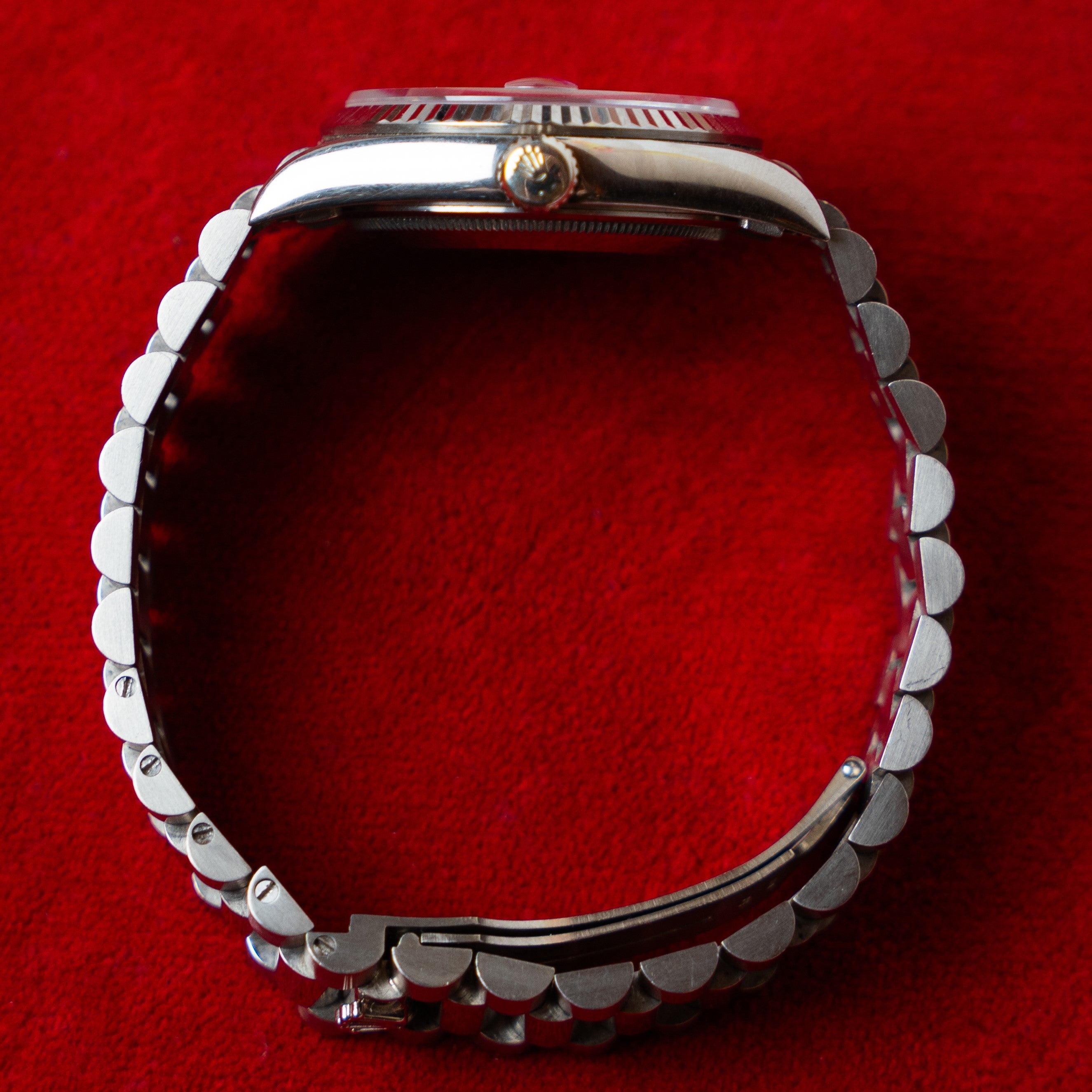 Rolex Day Date in 18 K white gold 36 MM case fluted bezel and Super President strap with a silver dial ornated with Roman numerals crown profile view