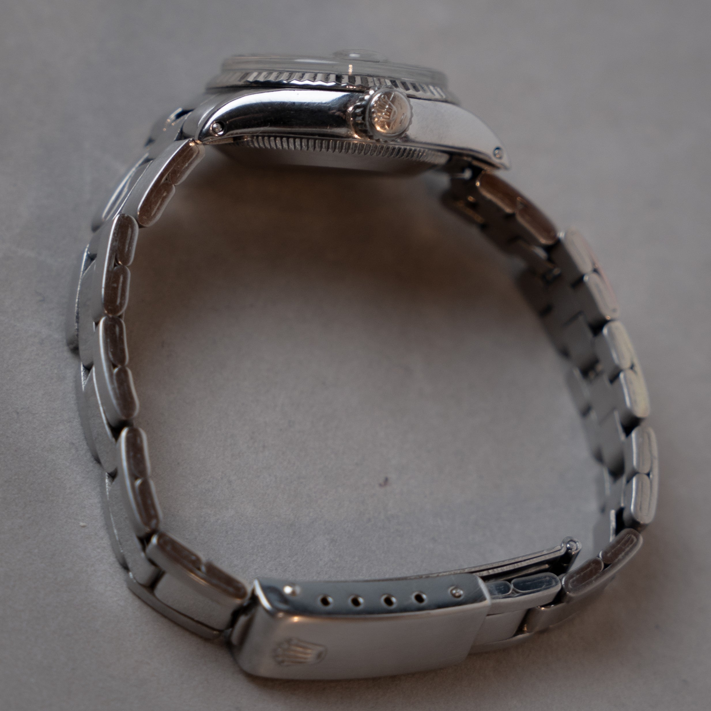 Rolex Oyster Date Lady self-winding vintage watch in steel with 18 carats white Gold fluted bezel, grey dial and plexi crystal on Oyster steel bracelet crown profile view