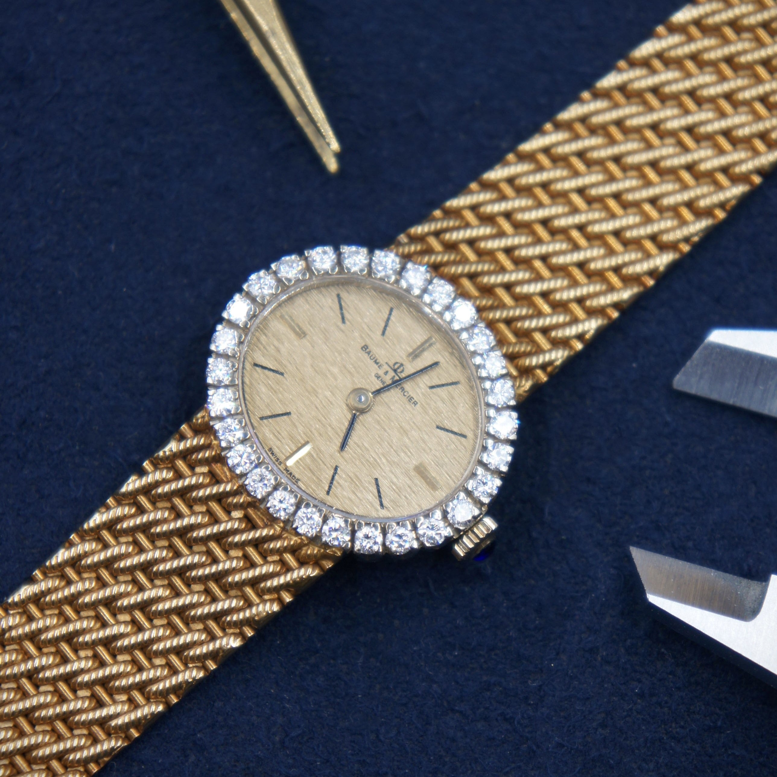 Beaume et Mercier Lady vintage watch ellipse shaped in 18 K gold and a diamonds set bezel with a manual winding movement and solid 18 K gold bracelet 3/4 angle view