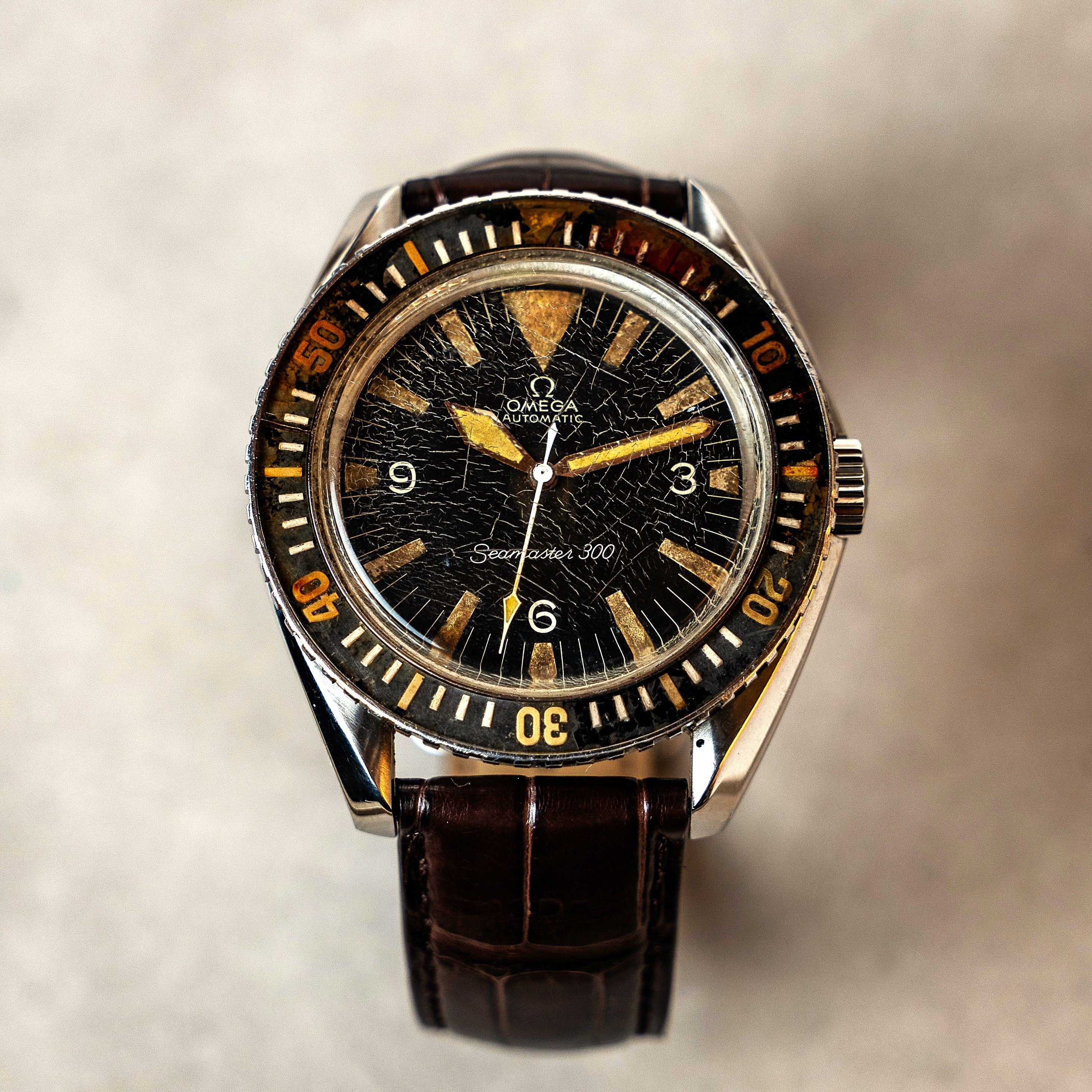 Omega Seamaster 300 automatic original vintage watch with Bakelite bezel the big triangle index at 12 o'clock  and dagger shaped hands and a beautiful patina all around face view