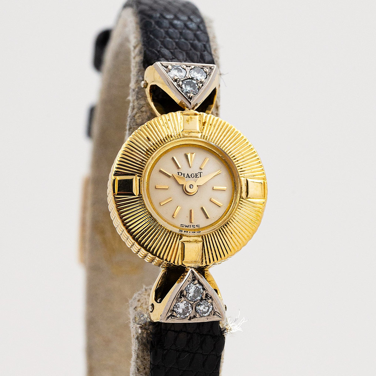 Piaget montre-bijou or jaune années 50, lunette rayonnante et attaches triangulaires serties de diamants